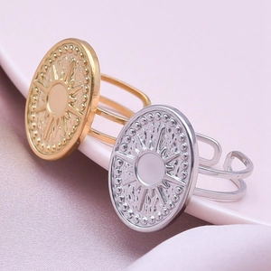 Detailed macro view of sunburst coin rings with adjustable open bands in gold and silver