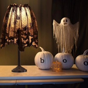 Detail view of black lace lampshade with spider web and bat patterns for Halloween decor