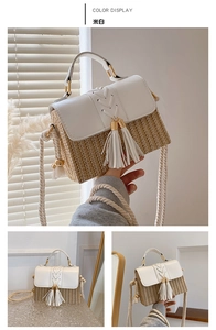 Detail of cream straw crossbody bag with leather flap and decorative dual tassels