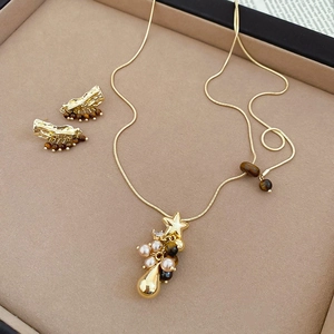 Détail du parure de bijoux étoile et perle vintage avec perles oeil de tigre dorées