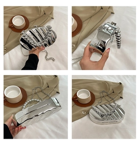 Detail of silver wavy evening bag with round bead handle and metal chain strap