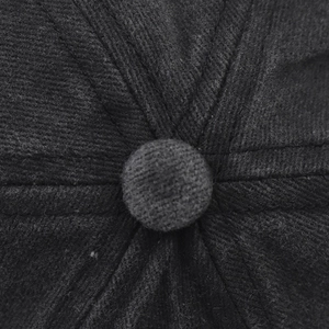 Macro shot of the top button and six-panel stitched structure of a washed cotton baseball cap