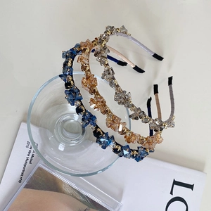 Detailed shot of sparkling crystal headbands in blue, amber, and grey on a glass edge