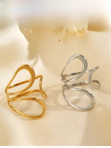 Macro detail of gold and silver hollow streamlined stainless steel rings on silk