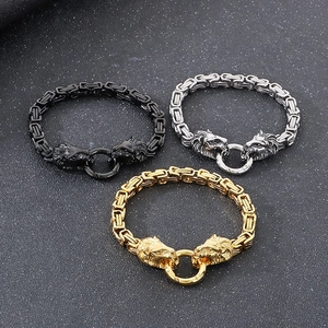 Three men's lion head steel bracelets in gold, silver, and black on a textured background