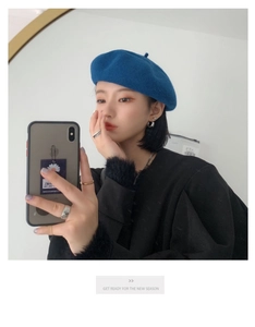 Close-up of blue wool beret with mirror selfie showcasing British retro style