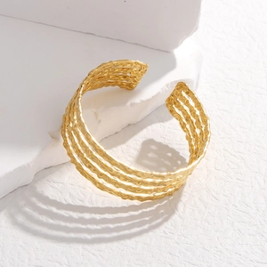 Detailed close-up of a four-layer gold irregular wave texture stainless steel open bangle