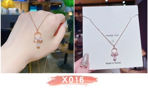 Macro di collana a fiocco oro rosa con ciondolo in zircone su scheda di esposizione
