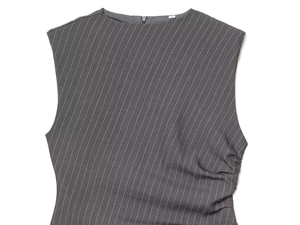 Detail of grey sleeveless dress featuring fine pinstripe texture and shoulder pads