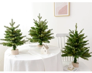 Close-up of three mini tabletop Christmas trees with LED lights and wooden bases