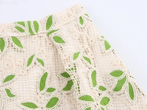 Détails de broderie au crochet et tissu en maille ajourée avec motifs de feuilles vertes