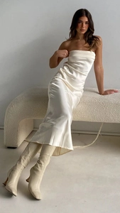 Dettaglio di un elegante abito midi in raso bianco sporco con schiena scoperta e stivali