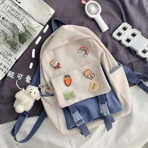Detail of minimalist school backpack with navy blue straps and cute cartoon badges