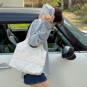 Photo en extérieur d'une femme portant un sac cabas en dentelle blanche pour les vacances