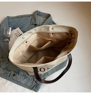 Detailed interior of a large canvas tote bag showing pockets and zipper compartment