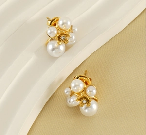 Close-up of pearl flower stud earrings with a gold metal center and vintage design