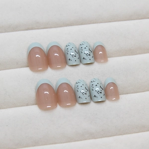 Short oval press-on nails with mint blue French tips and speckled quail egg patterns