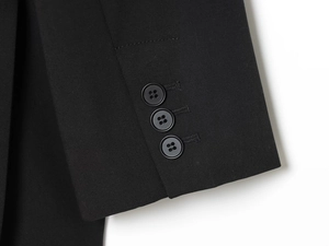 Detailed macro view of black blazer cuffs with three decorative four-hole round buttons