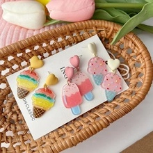 Three pairs of colorful resin ice cream earrings with heart studs on a display card