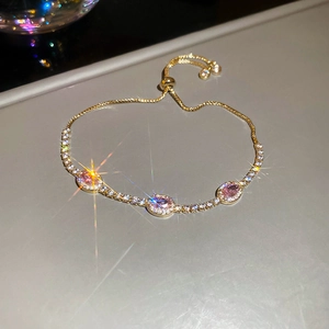 Macro view of gold-plated tennis bracelet with pink oval zircon and adjustable drawstring