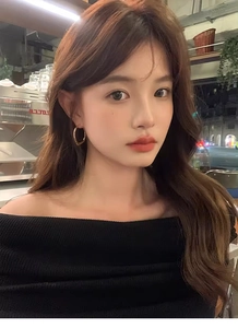 Close-up of elegant gold irregular hoop earrings worn by a model in a stylish cafe setting