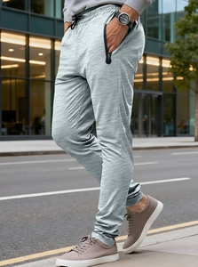 Detail of men's heather grey joggers showing zip pockets and elastic drawstring waist