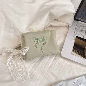 Morandi green bow canvas makeup bag with lace ribbon pendant on a white sheet