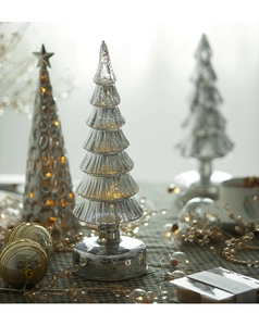 Detailed close-up of silver mercury glass Christmas tree with embossed texture and lights