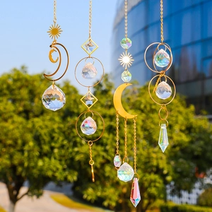 Golden suncatcher set with crystal balls, moons and stars hanging in natural sunlight
