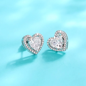 Close-up of heart-shaped stud earrings featuring silver metal and sparkling pave-set stones