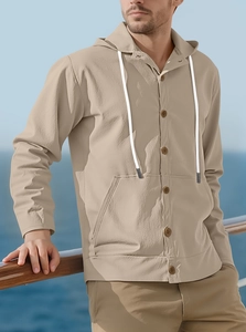 Detail of khaki linen hooded shirt featuring wooden buttons and waffle texture by the sea