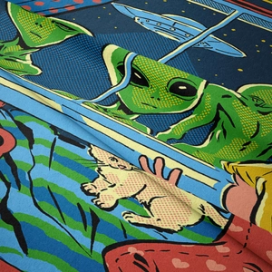 Dettaglio del tessuto morbido con motivi a fumetti colorati di alieni e gatti pop art