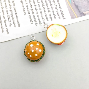 Detailed macro view of two DIY resin hamburger charms with metallic attachment rings