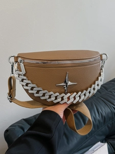 Close-up of tan pebble leather crossbody bag with silver chain and star metal detail