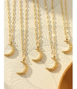 Detail of 18K gold-plated crescent moon necklaces with hammered texture and sequin chain