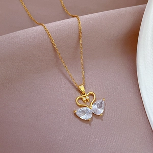 Macro shot of gold swan heart necklace with micro-pave white teardrop zircon crystals