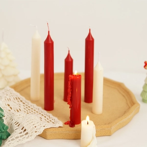 Detailed view of long tapered candles with realistic melting wax effect on wooden tray