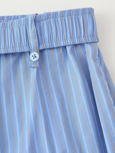 Detailed view of elastic waist with button and stripes on blue casual trousers