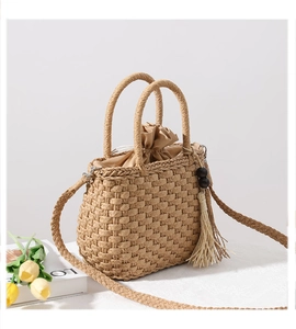 Detail of straw bag with wooden bead tassels, beige fabric lining and twin handles