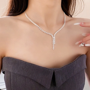 Close-up of a silver Y-shaped zircon tassel necklace worn on a model's collarbone