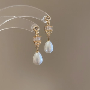 Detail showing 18k gold plated drop pearl earrings with sparkling zircon inlay