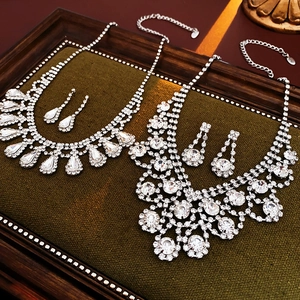 Detail of silver drop and cluster necklaces with earrings on luxury green velvet trays