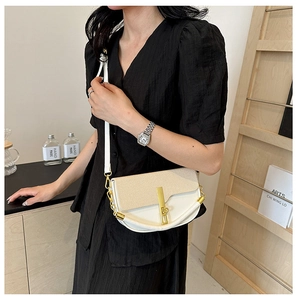 Detail of beige color-block crossbody bag featuring woven texture and gold chain hardware