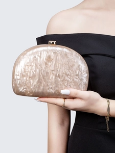 Close-up of pearl white marble textured acrylic evening clutch with metal clasp detail