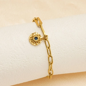 Dettaglio del bracciale a catena in oro 18K con ciondolo radiale e gemma blu scuro