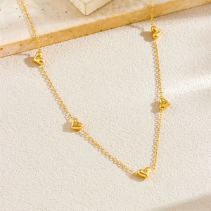Elegant gold stainless steel heart necklace with star accents on a stone background