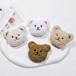 Close-up of cute plush bear heads in four colors for clothing and bag DIY decoration