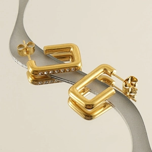 Detail view of 18K gold stainless steel earrings with sparkling zircon inlay and mirror finish