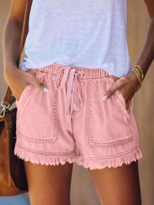 Gros plan sur un short en jean rose avec taille élastique à cordon et ourlets frangés