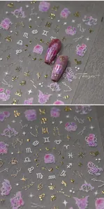 Macro view of gold foil zodiac nail stickers with purple nebula patterns and constellations